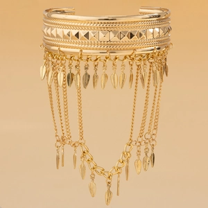 Detailed close-up of golden bohemian arm chain with leaf pendants and coin tassels