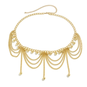 Detail of layered gold metal waist chain featuring round spherical charms and lobster clasp