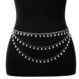 Détail d'une chaîne de taille argentée multicouche avec pendentifs étoiles et coquillages