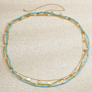 Detail of bohemian layered waist chain with blue seed beads and golden sequins