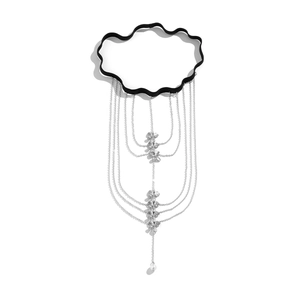 Detail of elastic black thigh chain with silver floral charms and a pearl drop pendant