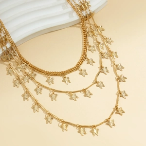 Détail de la chaîne de taille dorée à plusieurs rangs avec pendentifs papillons élégants
