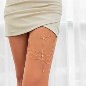 Detail of multi-layered gold thigh chain with sparkling round crystals on a model