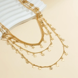 Détail rapproché de colliers dorés à plusieurs rangs avec de petits pendentifs étoiles