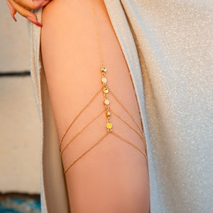 Detailed view of layered gold butterfly leg chain featuring sparkling stars and tassels