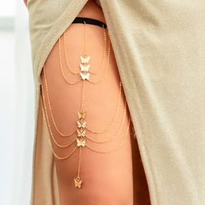 Close-up of gold butterfly tassel leg chain with elastic band and layered metal chains