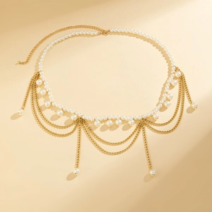 Detail of layered gold waist chain with elegant white pearls and delicate golden tassels