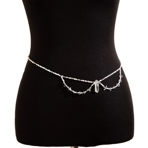 Détail d'une chaîne de taille en perles blanches avec pendentif en cristal sur un mannequin
