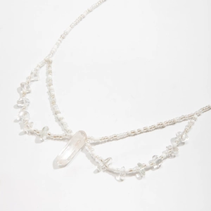 Détail de la chaîne de taille bohème avec perles blanches et pendentif en cristal
