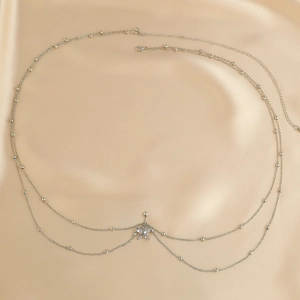 Primer plano de cadena corporal plateada con colgante de mariposa de diamantes de imitación