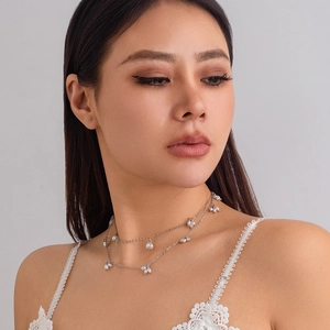 Détail d'un collier de perles élégant à deux couches avec chaîne argentée sur modèle
