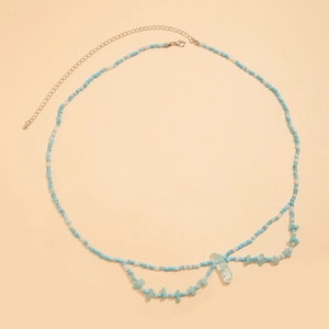 Détail de la chaîne de taille perlée bleue et blanche avec pendentif en cristal