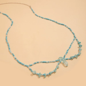 Détail de chaîne de taille bohème avec perles bleues et pendentif cristal quartz