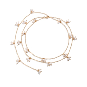 Détail d'un collier à plusieurs rangs doré avec des pampilles de perles blanches