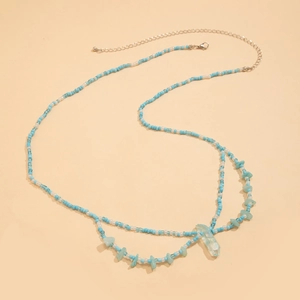 Détail de la chaîne de taille en perles bleues et blanches avec pendentif en cristal