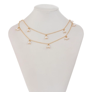 Détail du collier à deux rangs doré orné de petites perles blanches en grappes