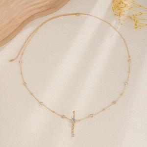 Detalle de cadena de cuerpo dorada con colgante de ombligo de circón y pequeñas perlas de cristal