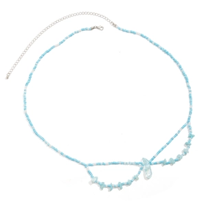 Détail de la chaîne de taille en perles bleues et blanches avec pendentif pierre bleue