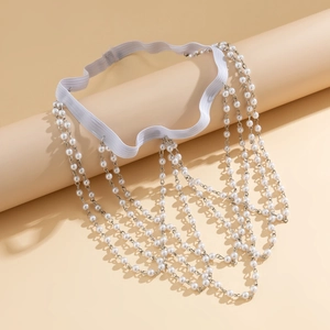 Macro detail of multi-layered pearl tassel leg chain with elastic band and silver links