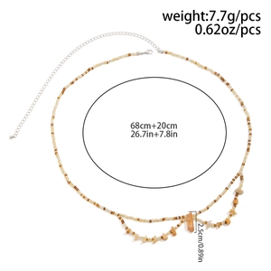 Détail de la chaîne de taille bohème avec perles ambrées, graviers naturels et fermoir mousqueton