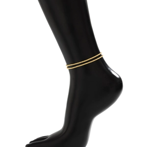 Close-up of double-layer gold anklet with sparkling woven chain on foot model