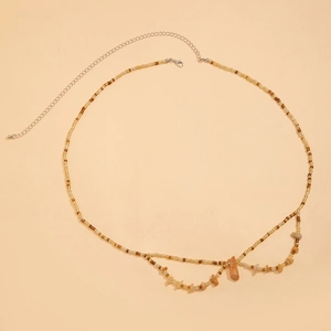 Détail de la chaîne de taille bohème avec perles ambrées et pendentifs en pierre naturelle