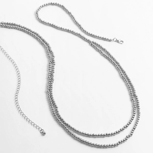 Détail de la chaîne de corps en perles argentées avec fermoir mousqueton et extension en métal