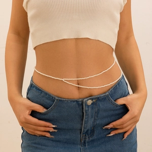 Chaîne de taille double rangée de perles portée avec un haut blanc et un jean bleu