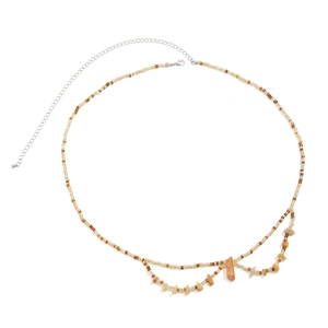 Détail d'une chaîne de taille bohème avec perles ambre et breloques en pierre naturelle
