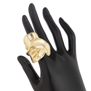 Vue détaillée d'une large bague dorée effet lave portée sur un modèle de main noir