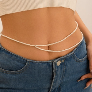 Détail d'une chaîne de corps double couche en perles portée sur un jean