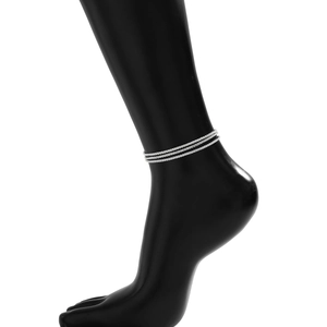 Close-up of triple-layered silver beaded anklet on a sleek black ankle model