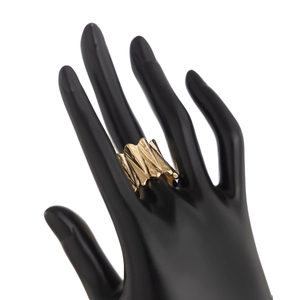 Gros plan détaillé d'une bague dorée style lave liquide avec texture ondulée en métal