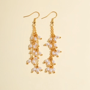 Détails de boucles d'oreilles pendantes à pampilles, perles ovales et chaînes dorées