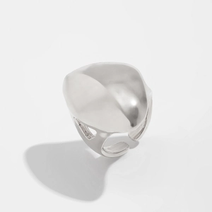 Détail macro d'une bague en métal argenté liquide avec surface abstraite polie et fluide
