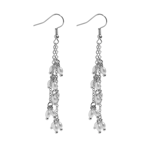 Détail de boucles d'oreilles à pampilles argentées avec perles blanches et longues chaînes