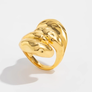 Détail macro d'une bague lave dorée avec une finition métallique texturée et brillante