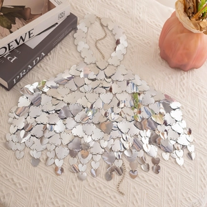 Detailed view of silver heart sequins body chain on a beige jacquard tablecloth background