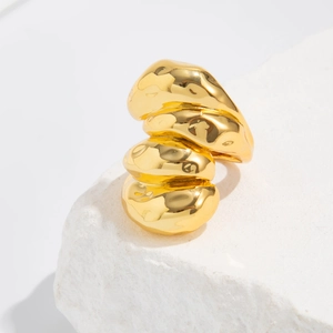 Vue macro de la bague lave dorée sur pierre montrant la finition polie brillante