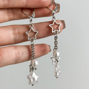 Détail des boucles d'oreilles à pampilles argentées avec pendentif étoile et perles baroques