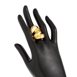 Détail macro de la bague dorée ondulée polie avec texture de métal liquide sur support noir