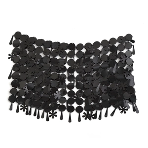Detalle de falda de cadena negra con lentejuelas, flores de resina y formas de gota