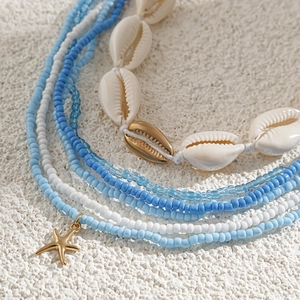 Detail van Boheemse lichaamsketting met blauwe kralen, schelpen en zeesterbedeltjes