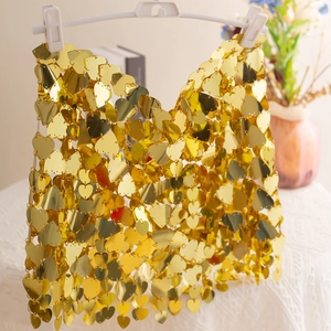 Detailed macro view of golden heart-shaped sequins linked by metal rings on a body chain