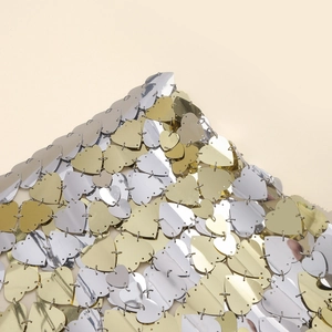 Close-up of heart-shaped gold and silver sequins connected with metal rings for body chain