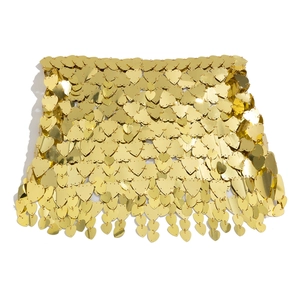 Detailed view of golden heart-shaped sequins connected by metal rings on a mini skirt