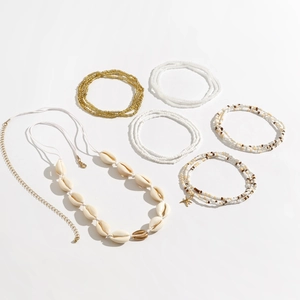 Detail van bohemien schelpenketting en kralenarmbanden set voor strandvakantie