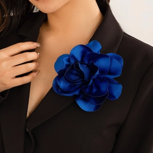 Dunkelblaue Satin-Blumenbrosche an einem schwarzen Revers für einen eleganten Abendlook