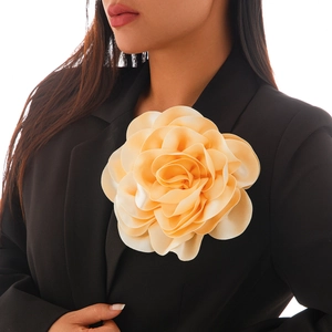 Detail of elegant satin rose brooch in champagne beige on a black blazer lapel
