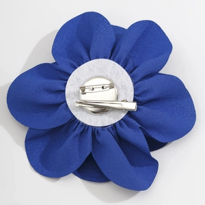 Detail der Rückseite der blauen Stoffblume mit Doppelclip und Sicherheitsnadel